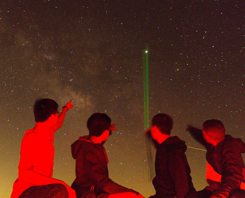 green laser pointing at stars with viewers